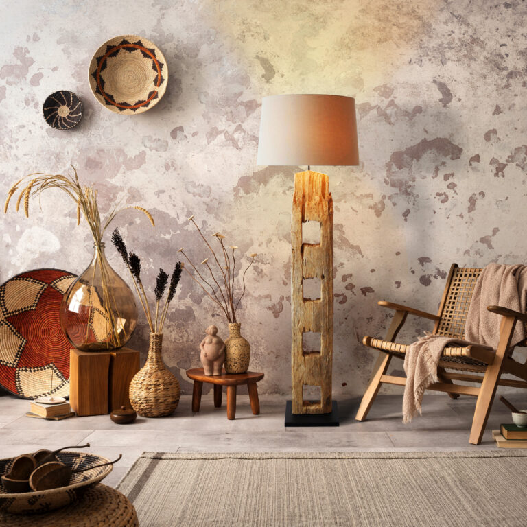 The stylish ethnic composition at living room interior with design brown armchair, colorful baskets, rattan sideboard and elegant personal accessories. Grey concrete wall. Cozy apartment. Home decor.